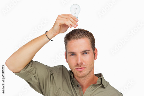 Man holding light bulb above his head