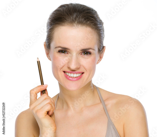 Beauty portrait of smiling young woman holding brown eye liner