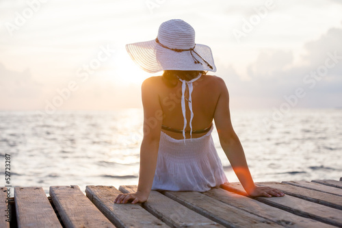 Caucasian woman takes rest at wooden pier to Indian ocean © Maygutyak