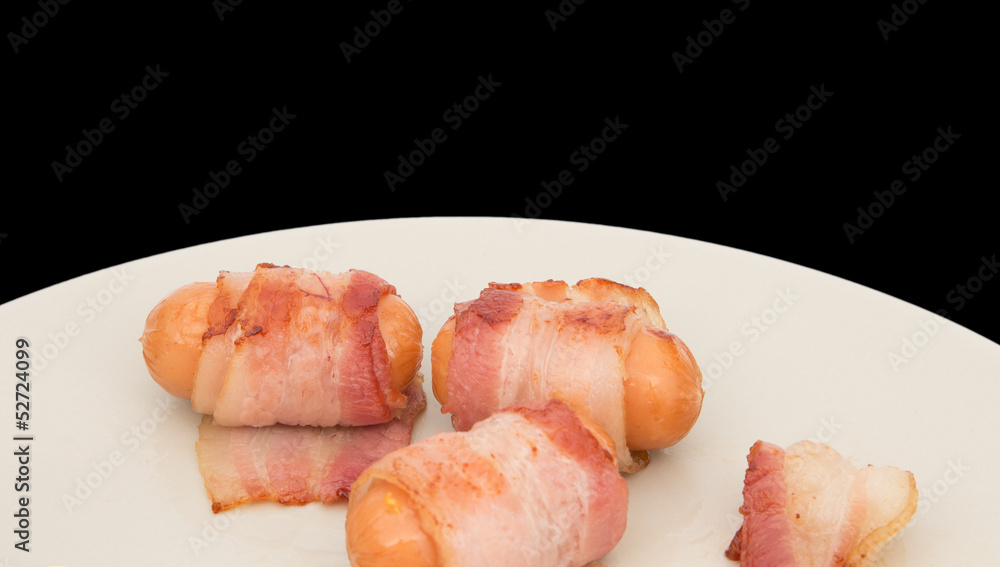 Bacon ham sausage on dish isolated on black