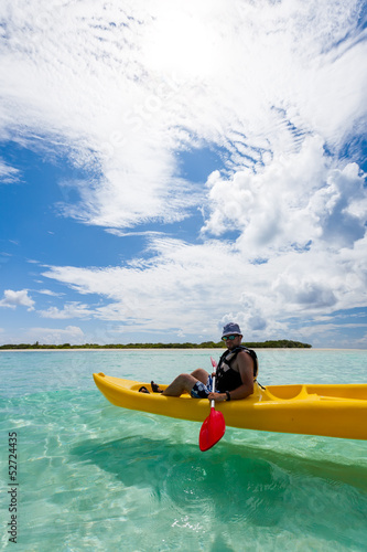 Young caucasian man kayaking in sea at Maldives © Maygutyak