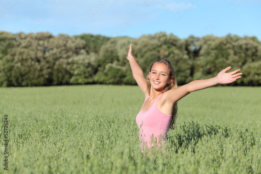 Beautiful teenager girl happy in a green meadow