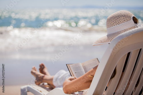Obraz na płótnie Woman relaxing and reading at the beach
