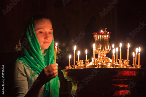 Girl with a candle in the Orthodox Church.