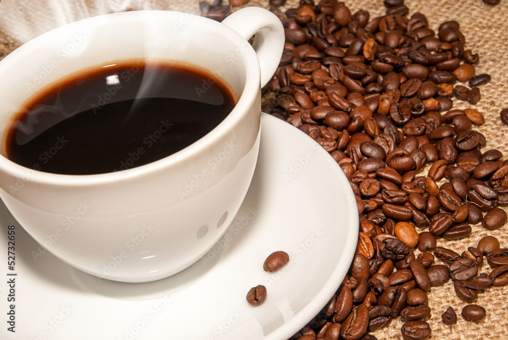white cup hot coffee and scattered coffee grains white cup hot coffee and scattered coffee grains
