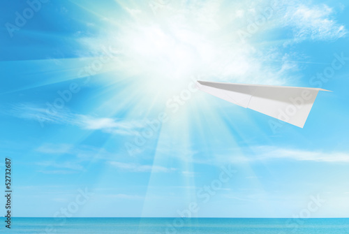 paper plane against the blue sky and sea