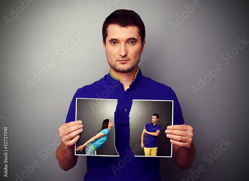 man tearing the photo of couple photo