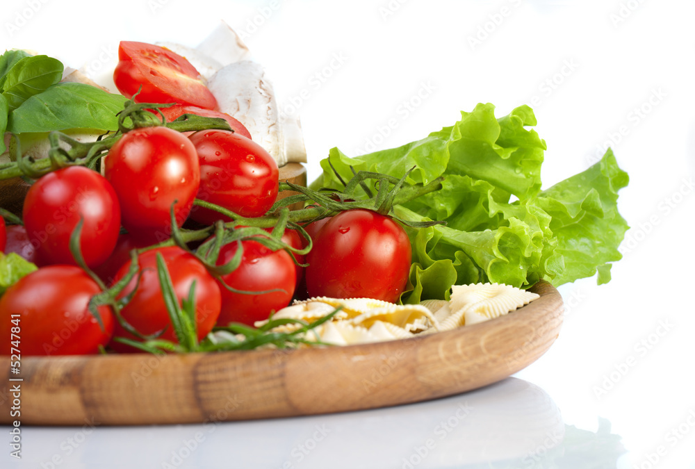 Fresh cherry tomatoes and salad in a wooden plate Fresh cherry tomatoes and salad in a wooden plate