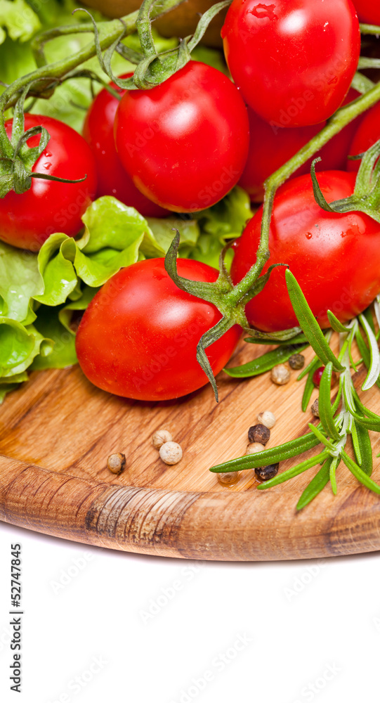 Fresh cherry tomatoes and salad in a wooden plate Fresh cherry tomatoes and salad in a wooden plate