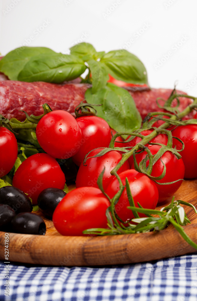 Fresh cherry tomatoes and salad in a wooden plate Fresh cherry tomatoes and salad in a wooden plate