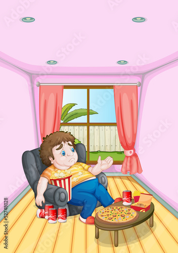 A fat young man in front of a table full of foods