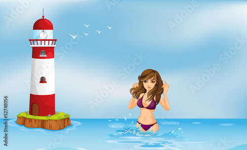 A girl wearing a bikini at the beach beside a tower