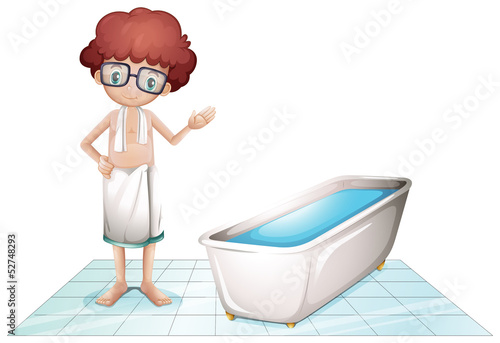 A boy with a towel beside a bathtub