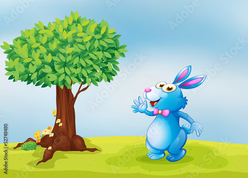 A blue bunny beside a tree
