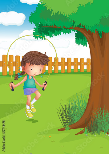 A girl playing with a jumping rope at the garden