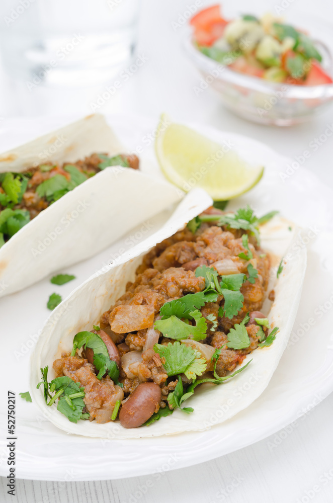 chili con carne in wheat tortillas on a plate and salsa vertical chili con carne in wheat tortillas on a plate and salsa vertical