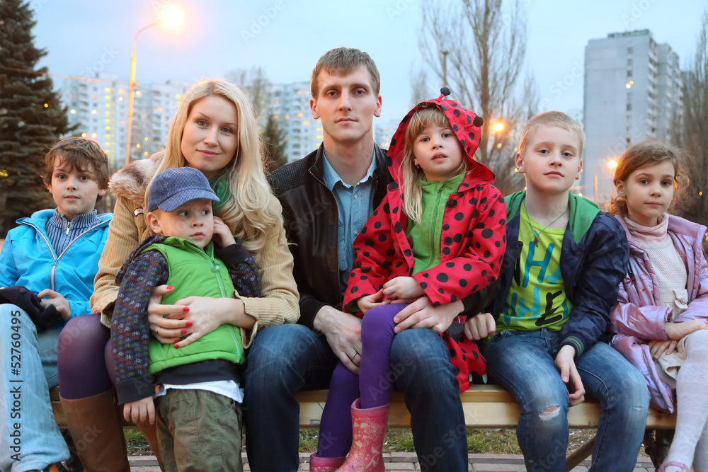 Fototapeta premium Big happy family in the evening sitting on the bench.