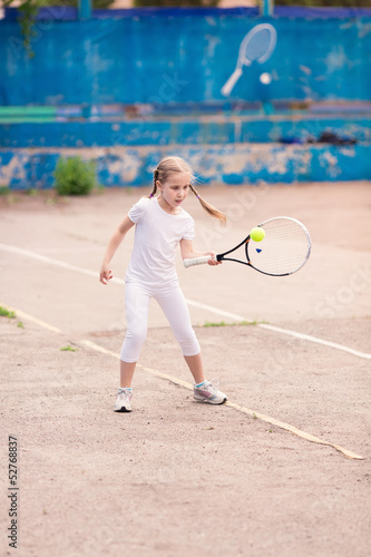 Adorable little child playing tennis