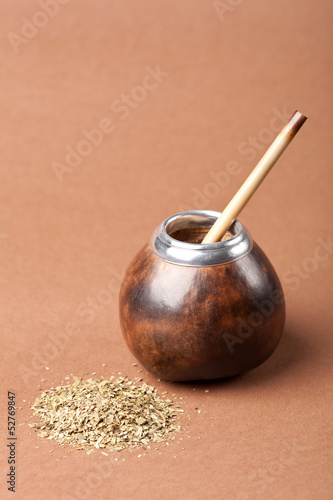 calabash and bombilla with yerba mate isolated on brown backgrou