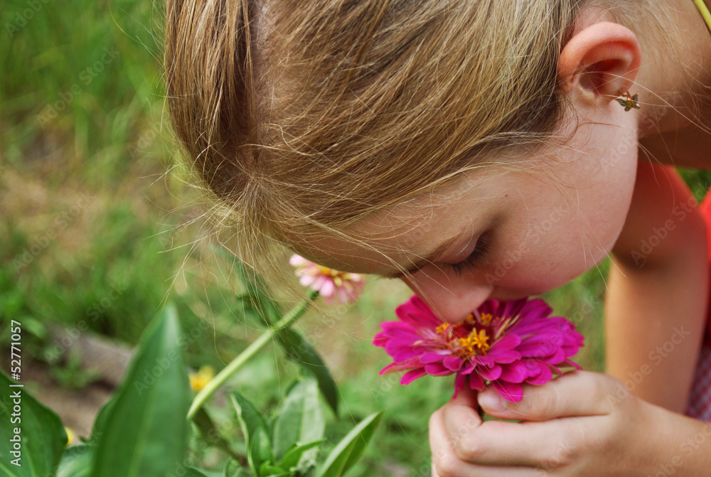 Naklejka premium Girl smelling a flower