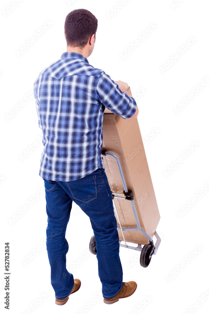 Fototapeta premium Young casual man moving a boxe with dolly, isolated on white bac