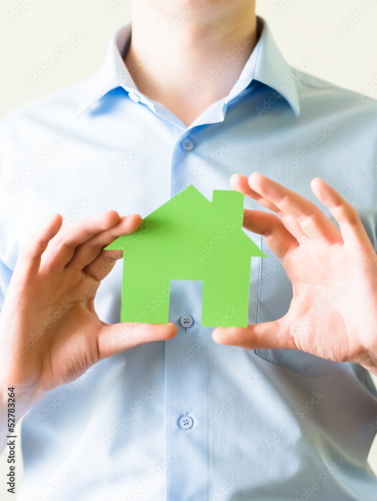 young man holding a paper house in hands young man holding a paper house in hands
