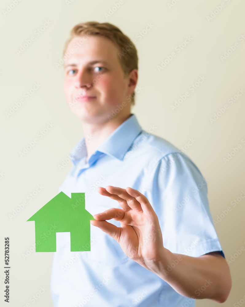 young man holding a paper house in hands young man holding a paper house in hands