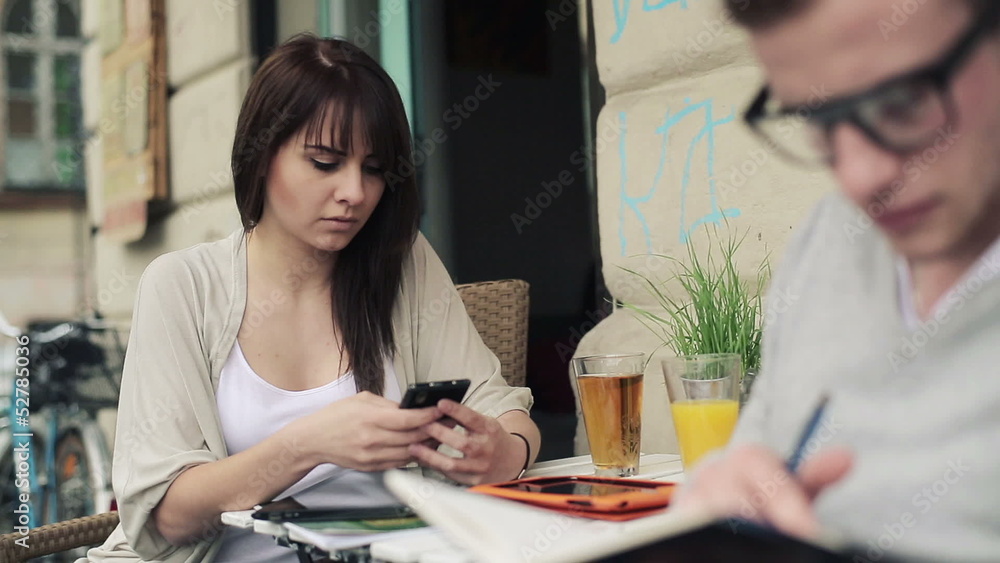 Young female student with smartphone in cafe, steadicam shot Young female student with smartphone in cafe, steadicam shot