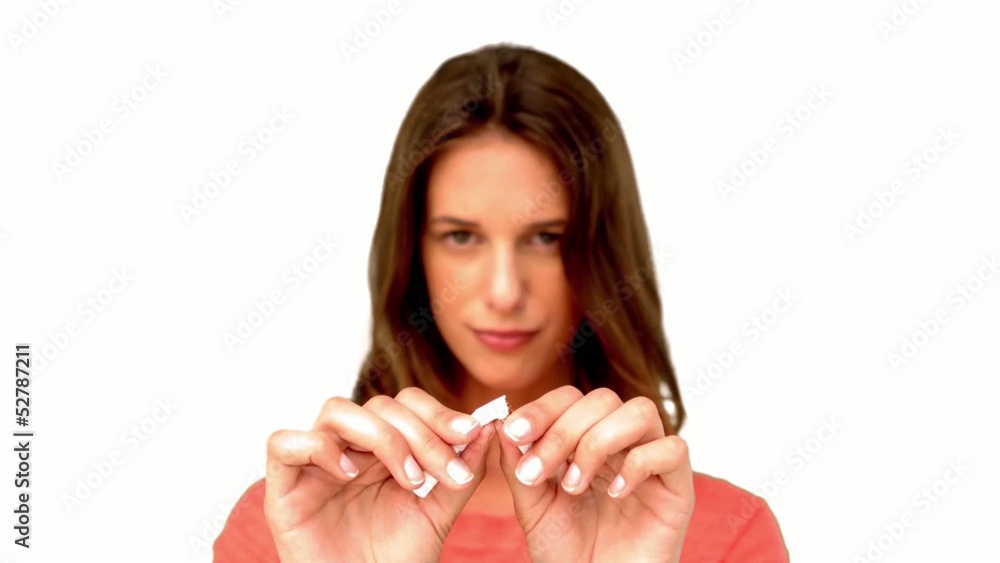 Brunette woman breaking a cigarette on white background Brunette woman breaking a cigarette on white background