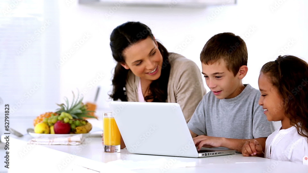 Mother looking at laptop with children Mother looking at laptop with children