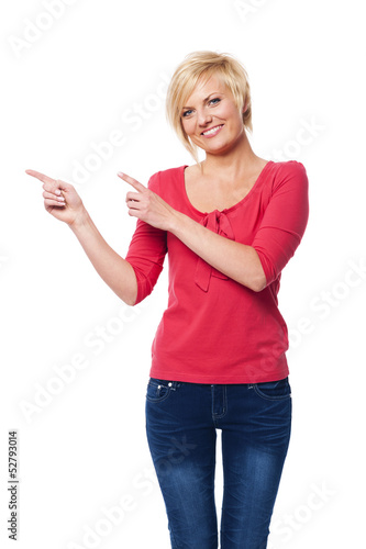 Blonde woman pointing at copy space.