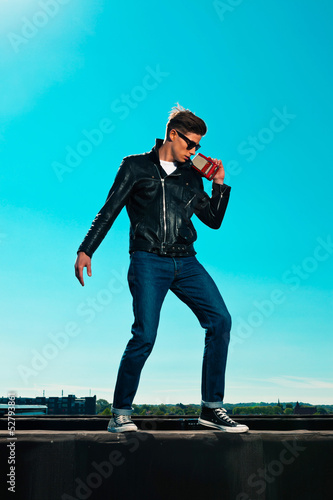 Rockabilly man retro 50s style with black jacket listens to port