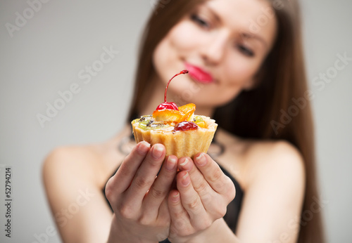 Young woman looking at the cake in her hands