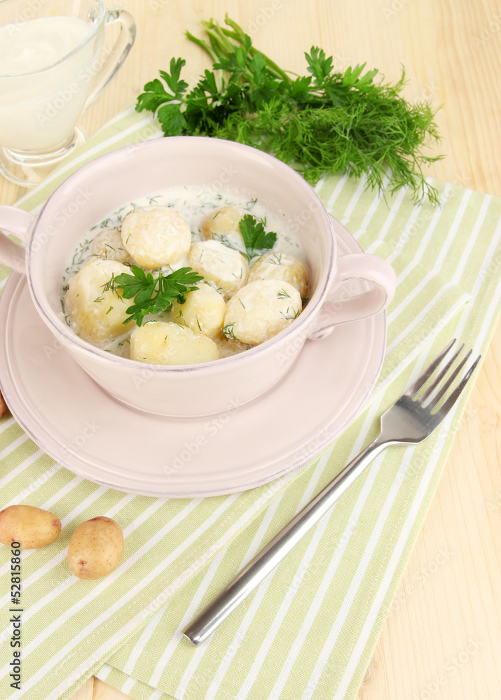 Tender young potatoes with sour cream and herbs in pan Tender young potatoes with sour cream and herbs in pan