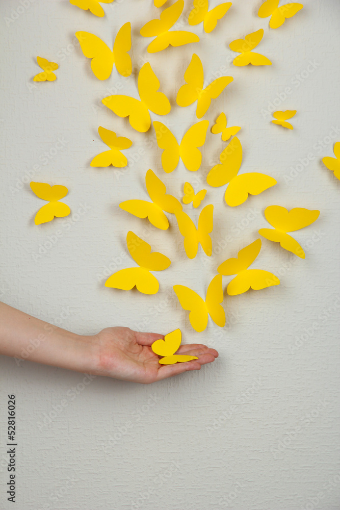 Paper yellow butterflies fly on wall in different directions Paper yellow butterflies fly on wall in different directions