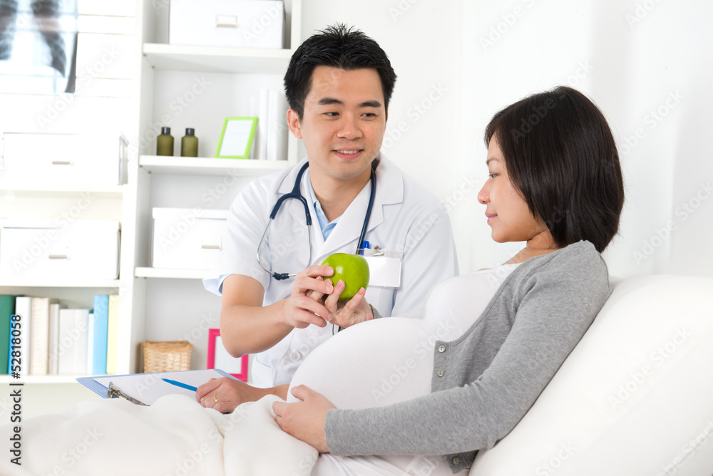 asian medical male doctor performing pregnancy check up asian medical male doctor performing pregnancy check up