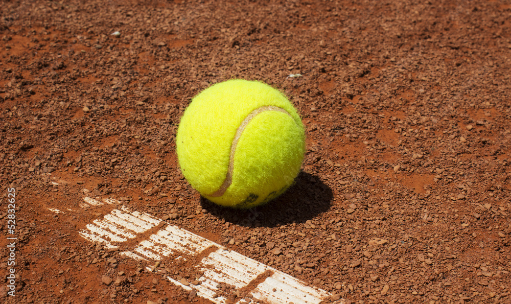 tennis ball on red clay