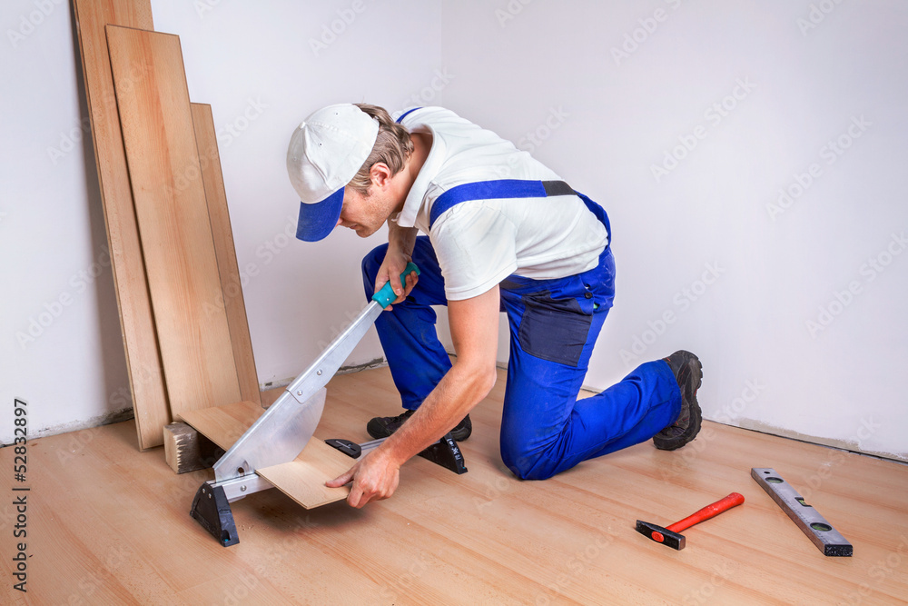 Male Worker laminate flooring.