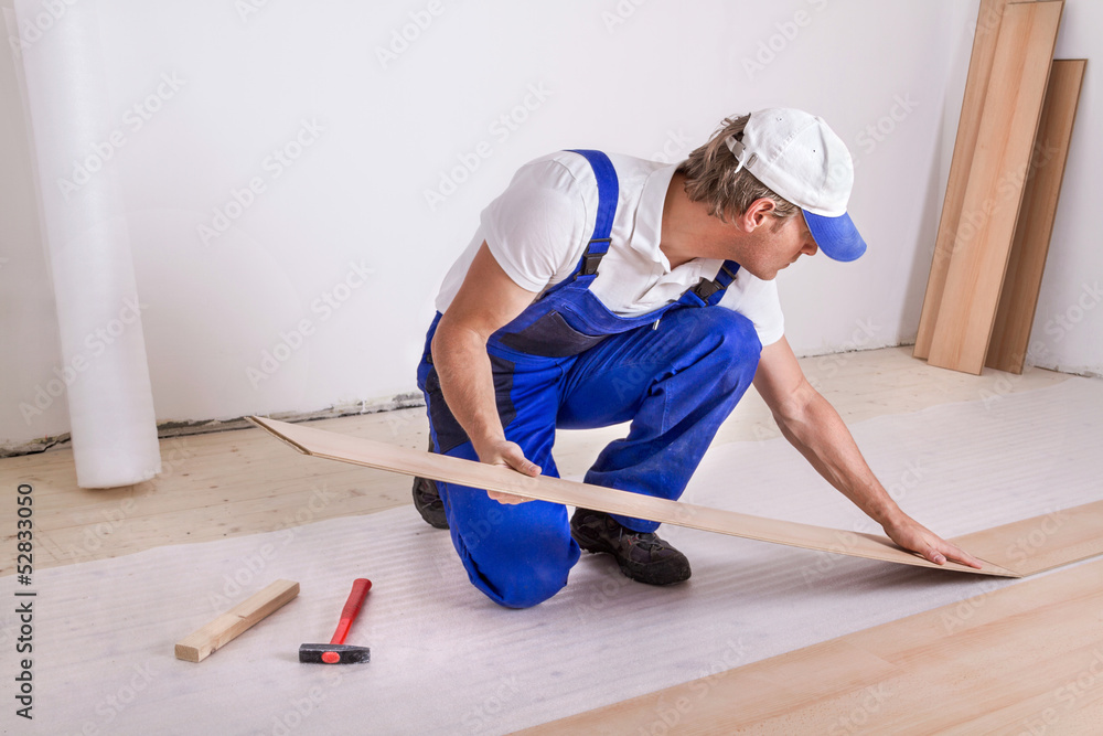 Male Worker laminate flooring.