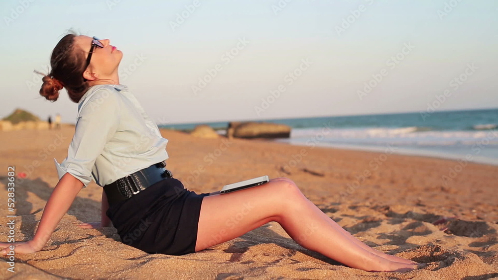 Sexy businesswoman with tablet computer relaxing on the beach Sexy businesswoman with tablet computer relaxing on the beach