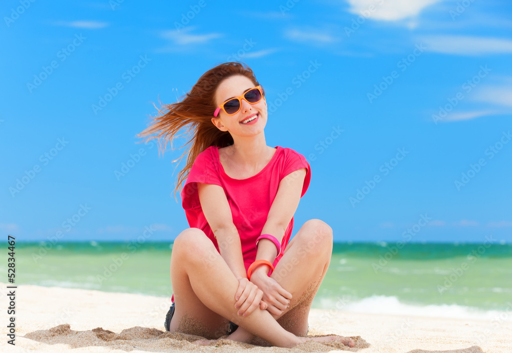 Funny teen girl sitting on the sand at the beach. Funny teen girl sitting on the sand at the beach.
