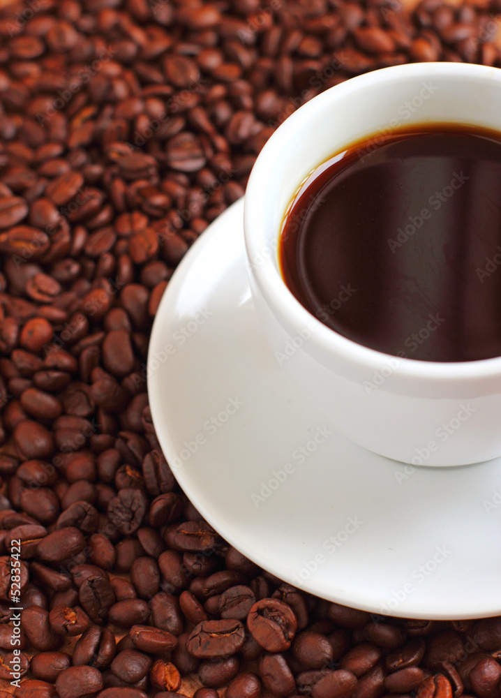 White cup of coffee on coffee beans White cup of coffee on coffee beans