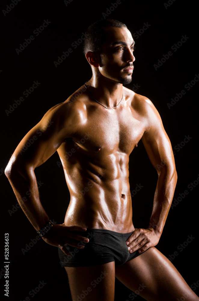 Muscular man in dark studio Muscular man in dark studio