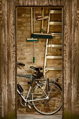 Retro styled image of a shed with a bicycle inside #52839099