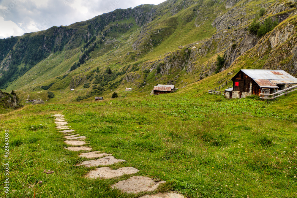 hiking path with wooden huts, Switzerland
