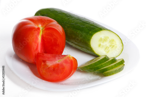 Slised tomatoes and cucumber on a white plate © wolf139