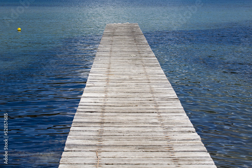 pier into the calm blue sea
