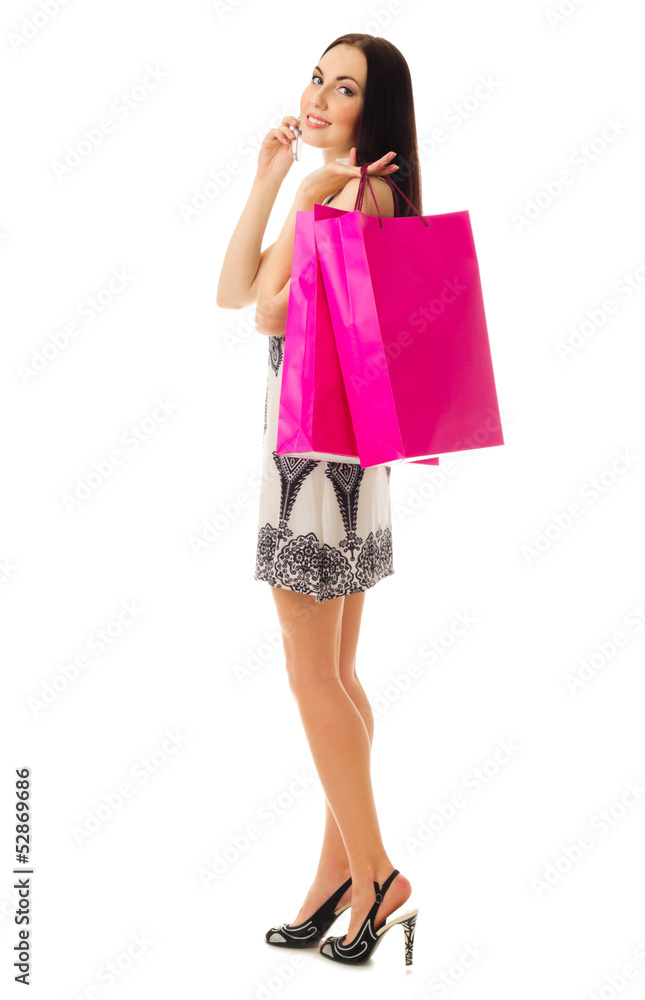 Young girl in black and white dress with bags talks by phone