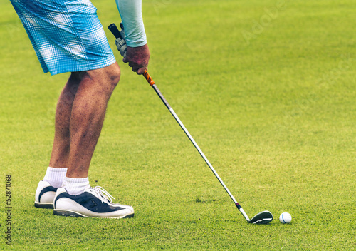 Closeup of of golfer putting on green