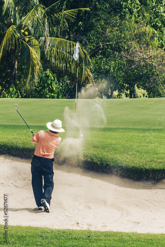 Asian golfer in bunker on golf course